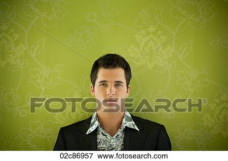 Stock Photo - Young man against floral wallpaper.. Fotosearch