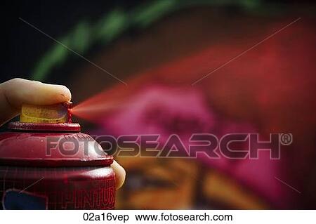 Stock Photography - Young man pressing red aerosol can. Fotosearch