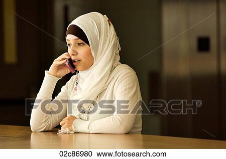 Stock Image - Young Muslim woman talking on cellphone.. Fotosearch