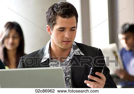 Young urban businessman using Blackberry PDA and wireless laptop in a hotspot cafe. View Large Photo Image Stock Image - Young urban businessman using Blackberry PDA and wireless laptop in a hotspot cafe.. Fotosearch