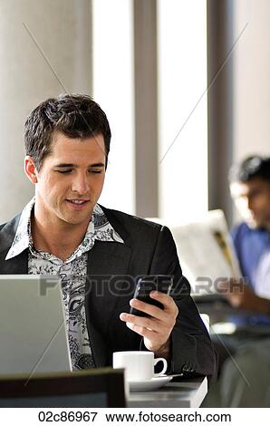 Young urban businessman using Blackberry PDA in wireless cafe. View Large Photo Image Stock Photo - Young urban businessman using Blackberry PDA in wireless cafe.. Fotosearch