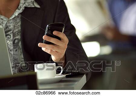 Young urban businessman using Blackberry PDA in cafe. View Large Photo Image Stock Photograph - Young urban businessman using Blackberry PDA in cafe.. Fotosearch