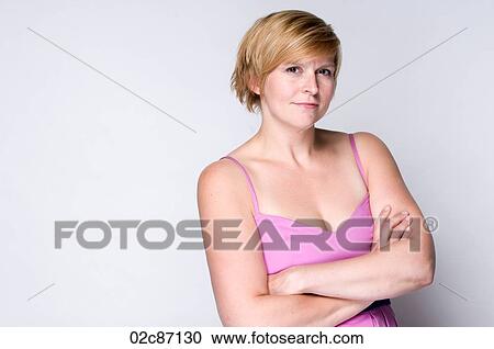 Stock Image - Young woman with crossed arms smiling.. Fotosearch