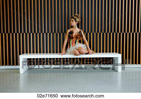 A glamorous woman sitting down a bench in a modern building View Large Photo Image Stock Image - A glamorous woman sitting down a bench in a modern building. Fotosearch