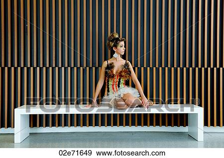 A glamorous woman sitting down a bench in a modern building View Large Photo Image Stock Photo - A glamorous woman sitting down a bench in a modern building. Fotosearch