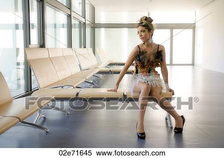 Stock Photography - A glamorous woman waiting in modern glazed room. Fotosearch