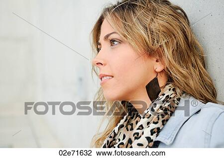 A stylish woman dressed in denim leaning against a wall View Large Photo Image Stock Image - A stylish woman dressed in denim leaning against a wall. Fotosearch