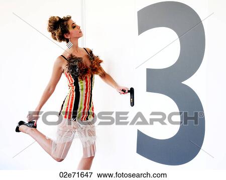 A woman opening a door with a giant number 3 on it View Large Photo Image Stock Photo - A woman opening a door with a giant number 3 on it. Fotosearch