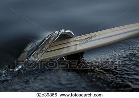Stock Photograph - An oar passing through the water on the lake at Lake of the Woods, Ontario. Fotosearch