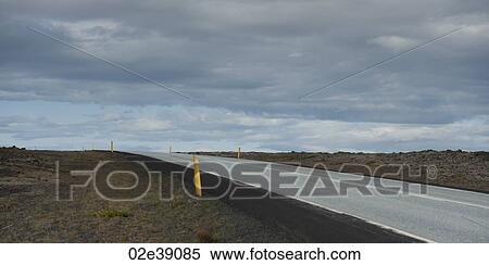 Barren highway disappearing over horizon under a cloudy sky View Large Photo Image Stock Photography - Barren highway disappearing over horizon under a cloudy sky. Fotosearch
