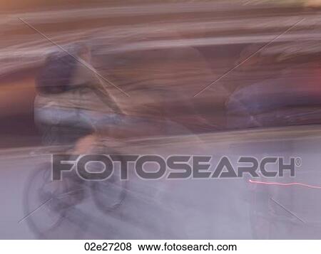 Blurred image of a person riding a bike in Paris France View Large Photo Image Stock Photo - Blurred image of a person riding a bike in Paris France. Fotosearch
