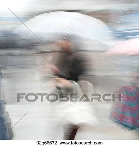 Stock Image - Blurred image of a woman holding an umbrella, Ginza, Chuo Ward, Tokyo, Japan. Fotosearch