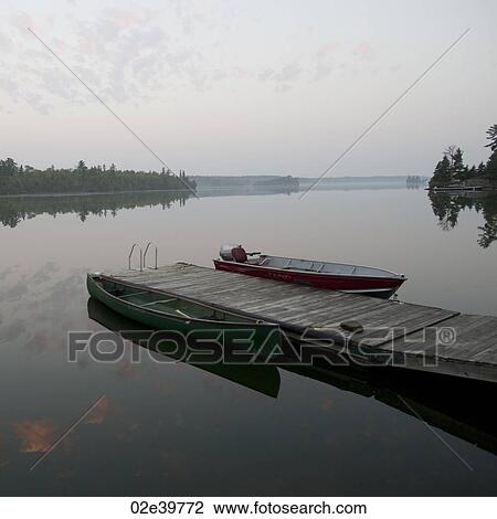 Stock Image - Boat at a dock in Lake of the Woods, Ontario. Fotosearch