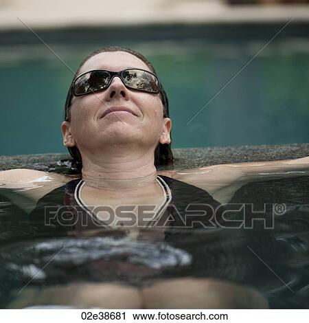 Stock Image - Brunette woman in a pool in Costa Rica. Fotosearch