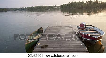 Canoe and motorboat at a dock in Lake of the Woods, Ontario View Large Photo Image Stock Image - Canoe and motorboat at a dock in Lake of the Woods, Ontario. Fotosearch