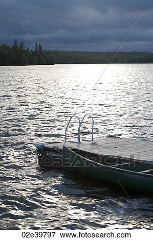 Stock Photo - Canoe at the dock in Lake of the Woods, Ontario. Fotosearch
