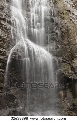 Cascading waterfall over steep rock face View Large Photo Image Stock Photo - Cascading waterfall over steep rock face. Fotosearch