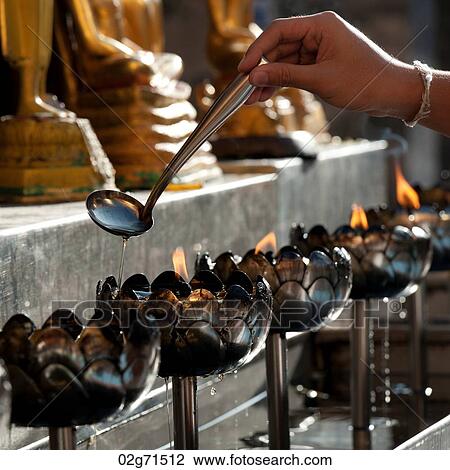 Close-up of a person's hand pouring oil into an oil lamp at Wat Phrathat Doi Suthep, Chiang Mai, Thailand View Large Photo Image Stock Image - Close-up of a person's hand pouring oil into an oil lamp at Wat Phrathat Doi Suthep, Chiang Mai, Thailand. Fotosearch