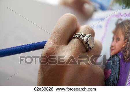 Close up of a ring on a hand drawing a picture View Large Photo Image Stock Photograph - Close up of a ring on a hand drawing a picture. Fotosearch
