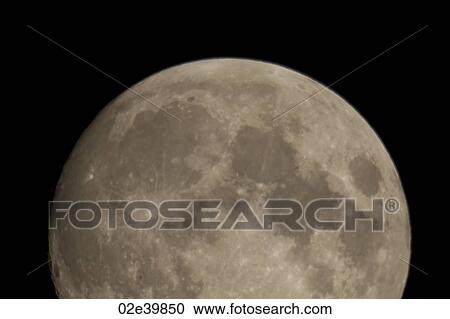 Stock Image - Close up of the moon in the night sky over Lake of the Woods, Ontario. Fotosearch