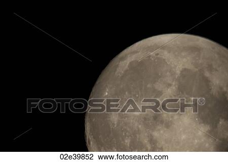 Stock Image - Close up of the moon in the night sky over Lake of the Woods, Ontario. Fotosearch