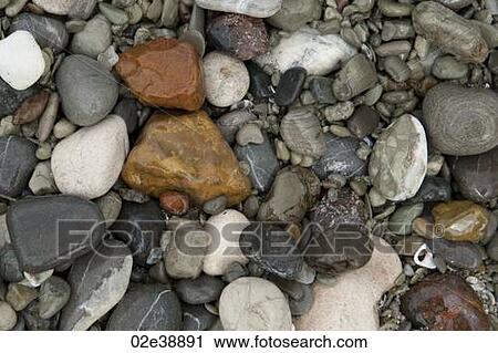 Stock Image - Coloured stones and pebbles along the shoreline in Costa Rica. Fotosearch