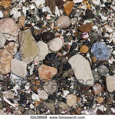 Stock Photo - Coloured stones and pebbles along the shoreline in Costa Rica. Fotosearch
