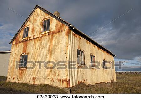 Corrugated rusty metal dwelling on grasslands under a stormy sky View Large Photo Image Stock Image - Corrugated rusty metal dwelling on grasslands under a stormy sky. Fotosearch
