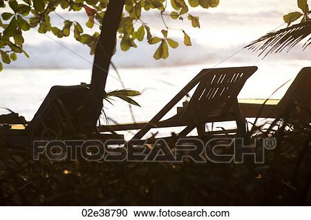 Stock Image - Deckchairs along Mal Pais coastline in San Jose Costa Rica. Fotosearch