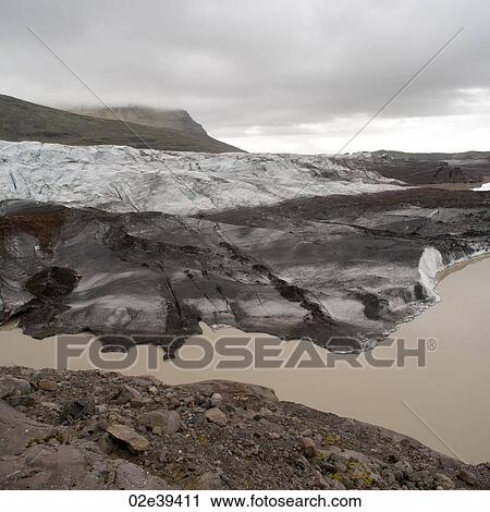 Dirty glacier melting into lake at shoreline, below misty mountain valley View Large Photo Image Stock Image - Dirty glacier melting into lake at shoreline, below misty mountain valley. Fotosearch