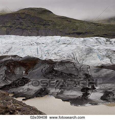 Dirty glacier melting into lake at shoreline, below misty mountain valley View Large Photo Image Stock Photo - Dirty glacier melting into lake at shoreline, below misty mountain valley. Fotosearch