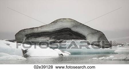 Dirty muddy melting iceberg floating in water View Large Photo Image Stock Photo - Dirty muddy melting iceberg floating in water. Fotosearch