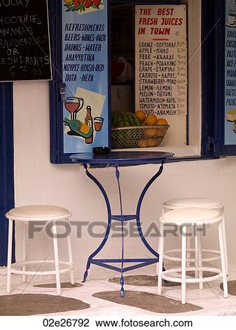 Stock Image - Empty table and stools in Mykonos Greece. Fotosearch