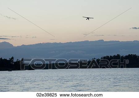 Float plane in the sky over Lake of the Woods, Ontario View Large Photo Image Stock Photography - Float plane in the sky over Lake of the Woods, Ontario. Fotosearch
