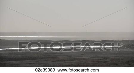 Stock Photo - Foggy ocean shoreline looking out upon the horizon. Fotosearch