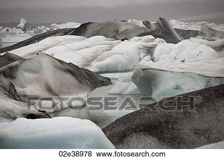 Frozen blue icebergs in a glacial lake View Large Photo Image Stock Photo - Frozen blue icebergs in a glacial lake. Fotosearch