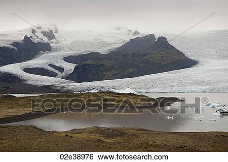 Stock Photograph - Frozen blue icebergs in a glacial lake. Fotosearch