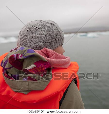 Girl in fluorescent orange life preserver, on glacial lake with icebergs View Large Photo Image Stock Image - Girl in fluorescent orange life preserver, on glacial lake with icebergs. Fotosearch