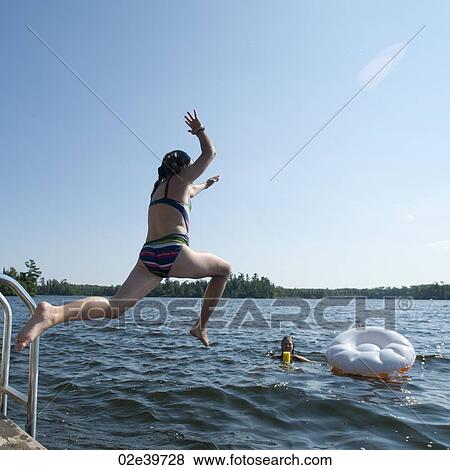 Girl jumping into the water at Lake of the Woods, Ontario View Large Photo Image Stock Photo - Girl jumping into the water at Lake of the Woods, Ontario. Fotosearch