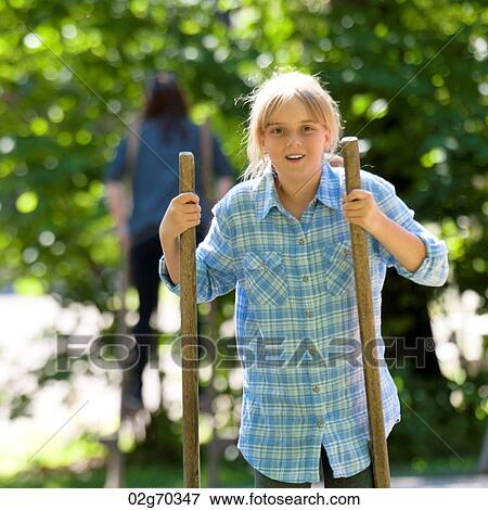Stock Photo - Girl walking with sticks in Norsk Folkemuseum, Oslo, Norway. Fotosearch
