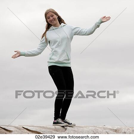 Girl with open arms balancing on rocks View Large Photo Image Stock Photo - Girl with open arms balancing on rocks. Fotosearch