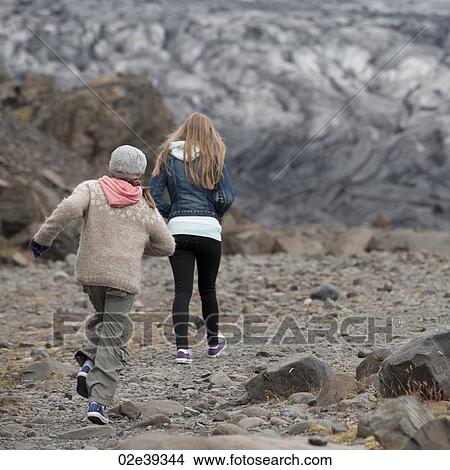 Girls walking away on glacial debris View Large Photo Image Picture - Girls walking away on glacial debris. Fotosearch