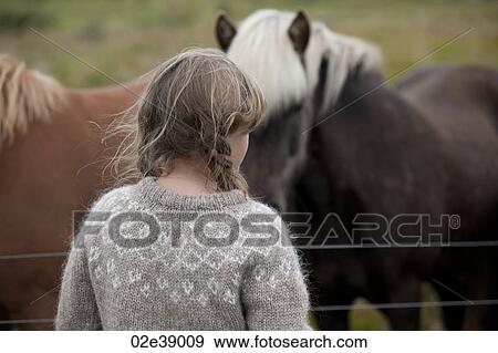 Head and back of girl with messy hair in knit sweater in front of Icelandic horses View Large Photo Image Stock Photo - Head and back of girl with messy hair in knit sweater in front of Icelandic horses. Fotosearch