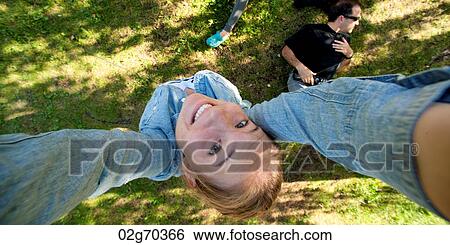 Stock Photograph - High angle view of a woman smiling with her arms raised, Norsk Folkemuseum, Oslo, Norway. Fotosearch