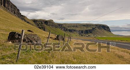 Highway and grass coastline along eroding mountain View Large Photo Image Picture - Highway and grass coastline along eroding mountain. Fotosearch
