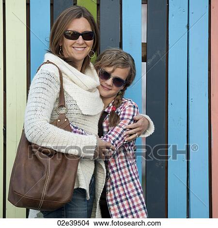 Hugging mother and daughter beside vertical stripes View Large Photo Image Picture - Hugging mother and daughter beside vertical stripes. Fotosearch