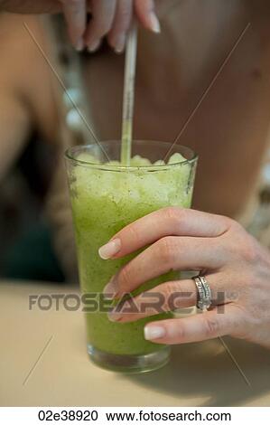 Iced green tea drunk through a straw by a woman with mainicured fingernails and diamond wedding and engagement rings View Large Photo Image Stock Image - Iced green tea drunk through a straw by a woman with mainicured fingernails and diamond wedding and engagement rings. Fotosearch