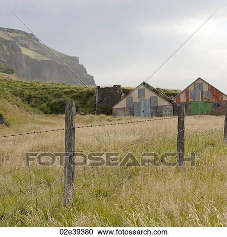 Landscape, abandoned barns in fenced pastureland, below mountain cliff View Large Photo Image Stock Image - Landscape, abandoned barns in fenced pastureland, below mountain cliff. Fotosearch