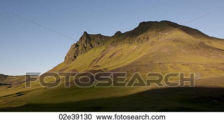 Stock Image - Landscape, grass covered eroding mountain peak. Fotosearch