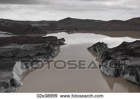 Stock Photo - Landscape of dirty melting glaciers in a glacial lake. Fotosearch